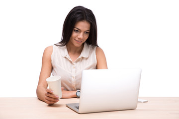 Happy businesswoman sitting at the table with laptop