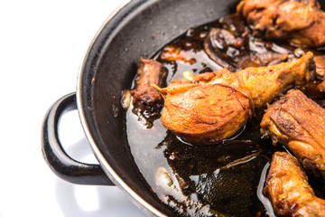 Deep fried chicken in with black soy gravy in a saute pan