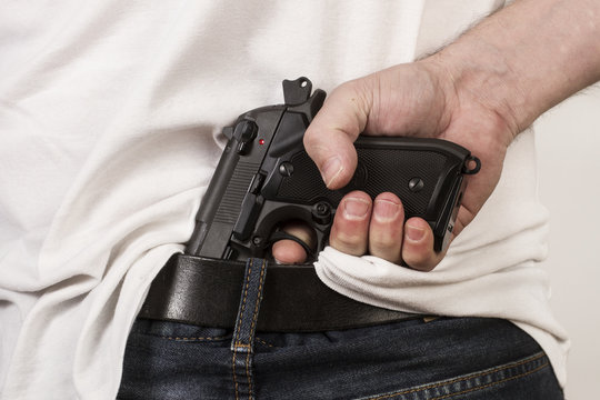 Hombre con Pistola automática en la cintura. Vista de frente y de cerca. Concepto violencia