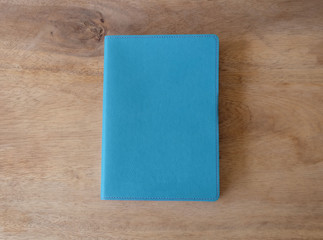 Sky blue leather notebook on wooden table, the personal organize