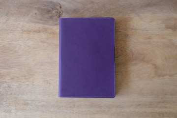 Purple leather notebook on wooden table, the personal organizer