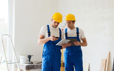builders with tablet pc and equipment indoors