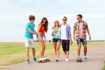 Obraz premium group of smiling teenagers with skateboards