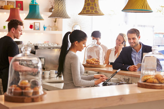 Young man ordering at the counter in a cafe