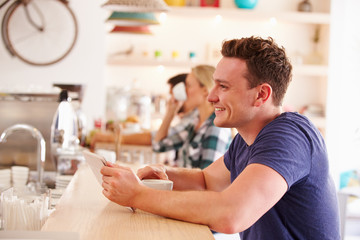 Young man using tablet computer in a cafe
