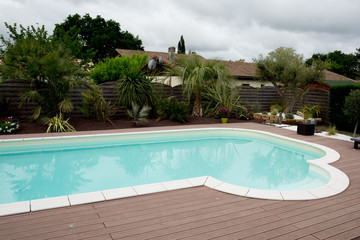 Fototapeta na wymiar Beautiful swimming pool with wooden floor around