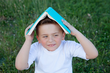 Little kid playing with a book at outside