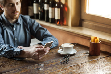 Hipster guy texting with his mobile phone