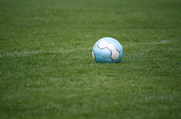 Fototapeta na wymiar Eisblauer Fußball auf Naturrasen