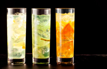 Three highball glasses filled with cocktail drinks