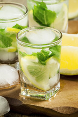 Glass of water with fresh lemon, ice and mint, selective focus