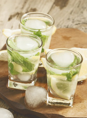 Glass of water with fresh lemon, ice and mint, selective focus