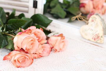 Beautiful bouquet of peach roses in shabby style on a mirror bac