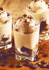 Traditional Italian dessert tiramisu in glass, selective focus