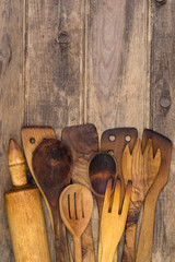 Wooden kitchen utensils on wooden background with copy space