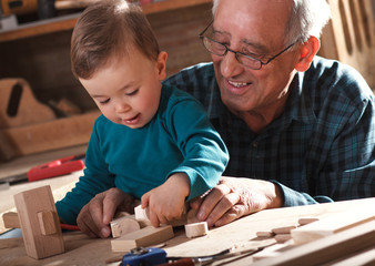Senior carpenter and his grandson working in the workshop