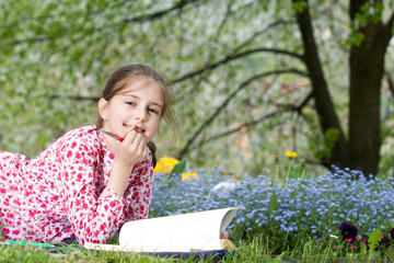 Young girl reading a book outdoor