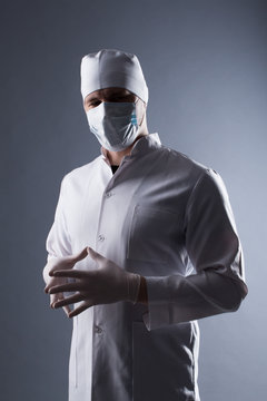 Male Doctor In Cap And Mask Wear Rubber Medical Gloves In Contra