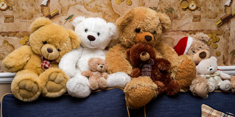 a group of cute teddy bears sitting together on the sofa