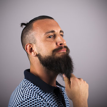 Hipster toc&aacute;ndose la barba