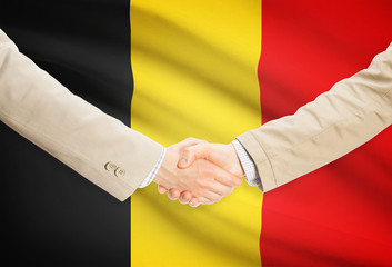 Businessmen handshake with flag on background - Belgium