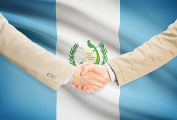 Businessmen handshake with flag on background - Guatemala