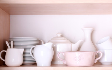 Fototapeta na wymiar Kitchen utensils and tableware on shelf