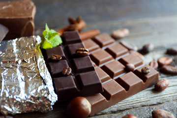 Delicious chocolate with spices on wooden table, closeup