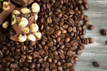 Chocolate with mint and coffee beans on wooden table, closeup