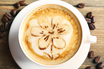 Cup of coffee latte art on wooden table, closeup
