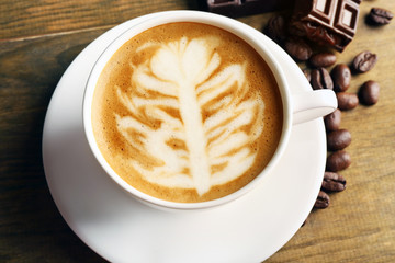 Cup of coffee latte art on wooden table, closeup