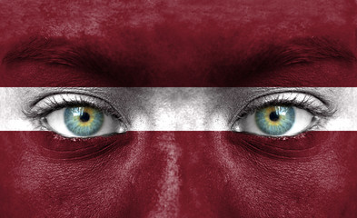 Human face painted with flag of Latvia