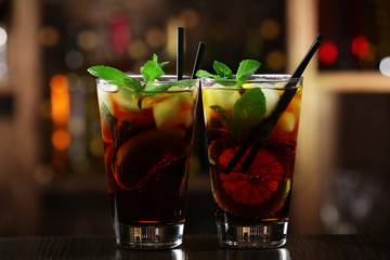 Glass of cocktail in bar on bright blurred background