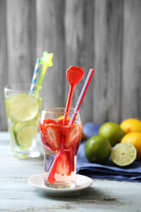Cocktails with fresh strawberries and lemon lime on wooden background
