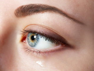 Fototapeta na wymiar Eye of young woman with tear drop close up