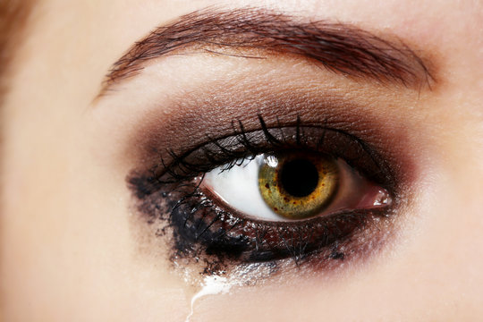 Eye of young woman with tear drop close up