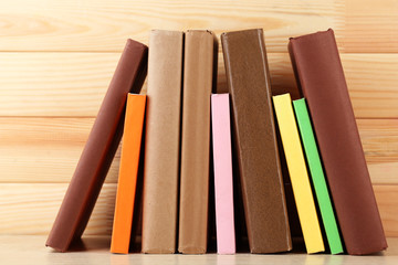Books on shelf, close-up, on wooden background