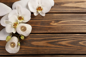Fototapeta premium Spa stones and orchid flower on wooden background