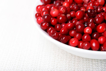Cranberries in bowl on table close up
