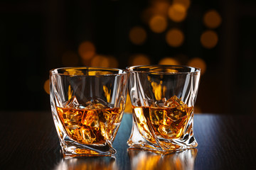 Glasses of whiskey on bar background