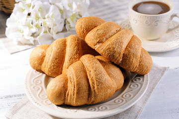 Delicious croissants on plate on table close-up
