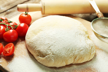 Dough on cutting board with cherry on table close up