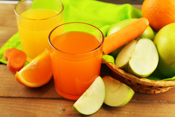 Glass of healthy fresh juice of apples and carrots on wooden background
