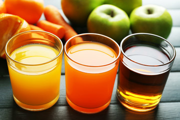 Assortment of healthy fresh juices and fruits on wooden table background