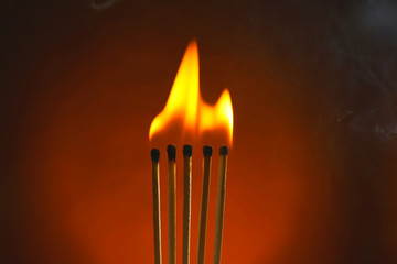 Fototapeta premium Burning matches with smoke on dark color background