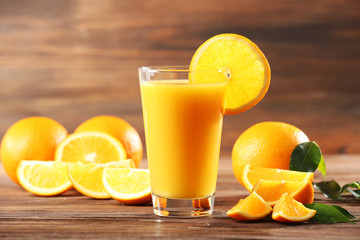 Orange juice on table on wooden background