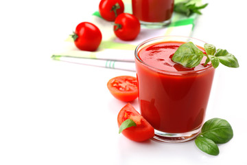 Glasses of fresh tomato juice on checkered napkin, isolated on white