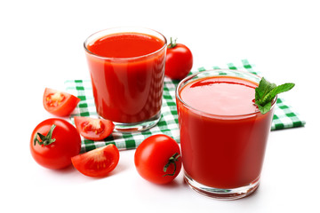 Glasses of fresh tomato juice on checkered napkin, isolated on white