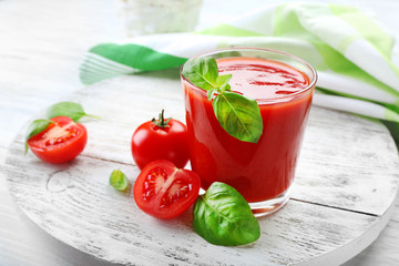 Glass of fresh tomato juice on wooden table, closeup