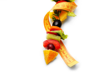 Snack of vegetables on fork with measuring tape isolated on white